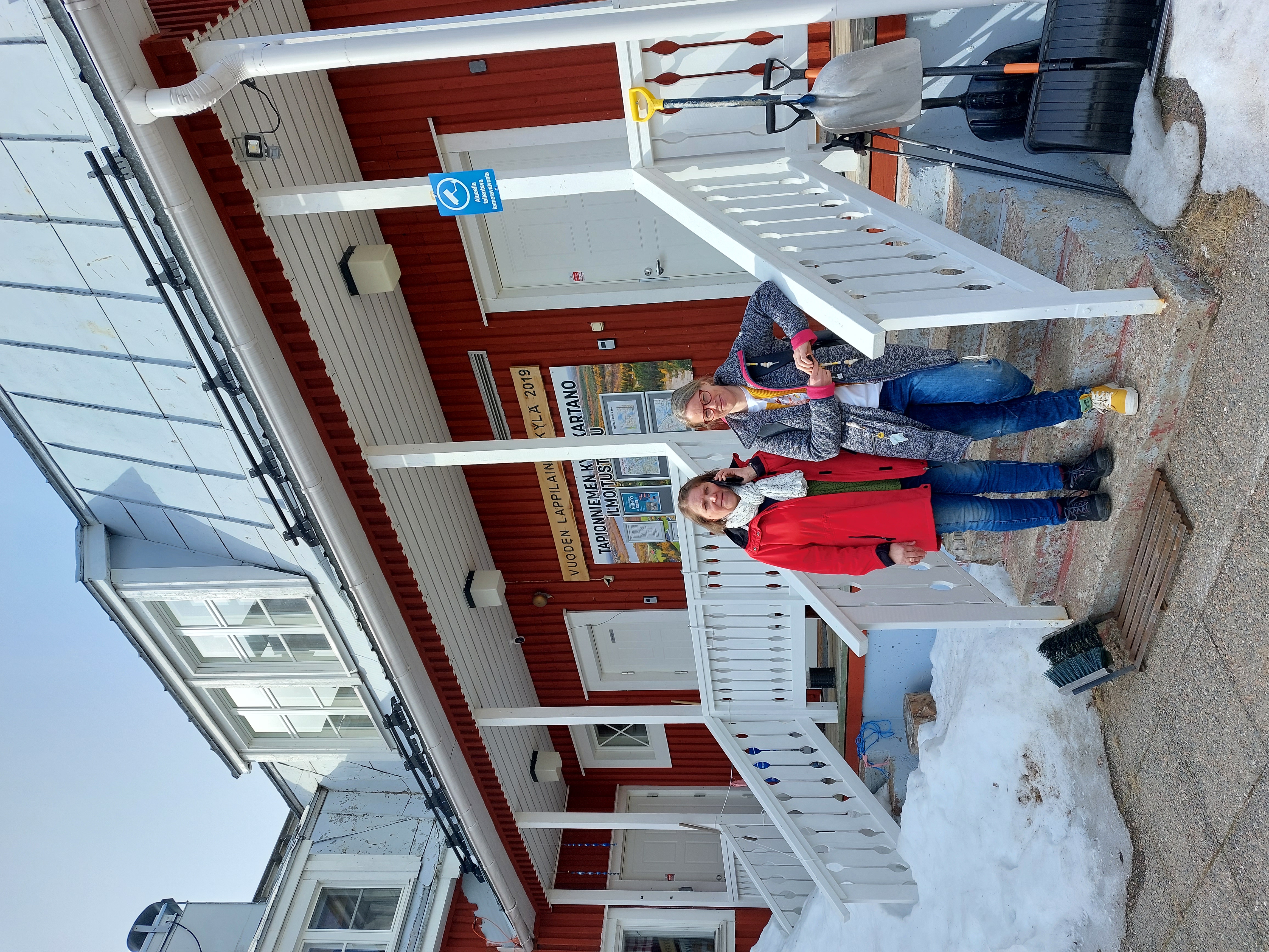 Sirkka Nissi-Onnela ja Henna Saarela seisovat ulkona Tapionniemen kyläkartanon portailla.